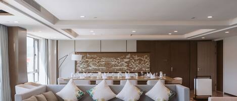 A modern hotel lobby with a sofa set, a coffee table with amenities, and a decorative wall.