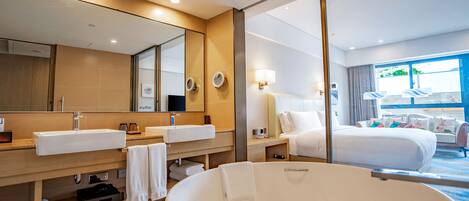 Un baño de hotel moderno con una bañera grande, dos lavamanos y un espejo amplio.