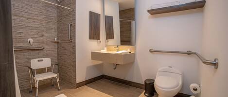 A modern bathroom with a shower, toilet, and sink.