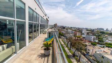 Un edificio moderno con ventanas amplias y un balcón que da a una vista urbana.