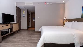 A hotel room with a bed, a TV, a desk, and a wardrobe.