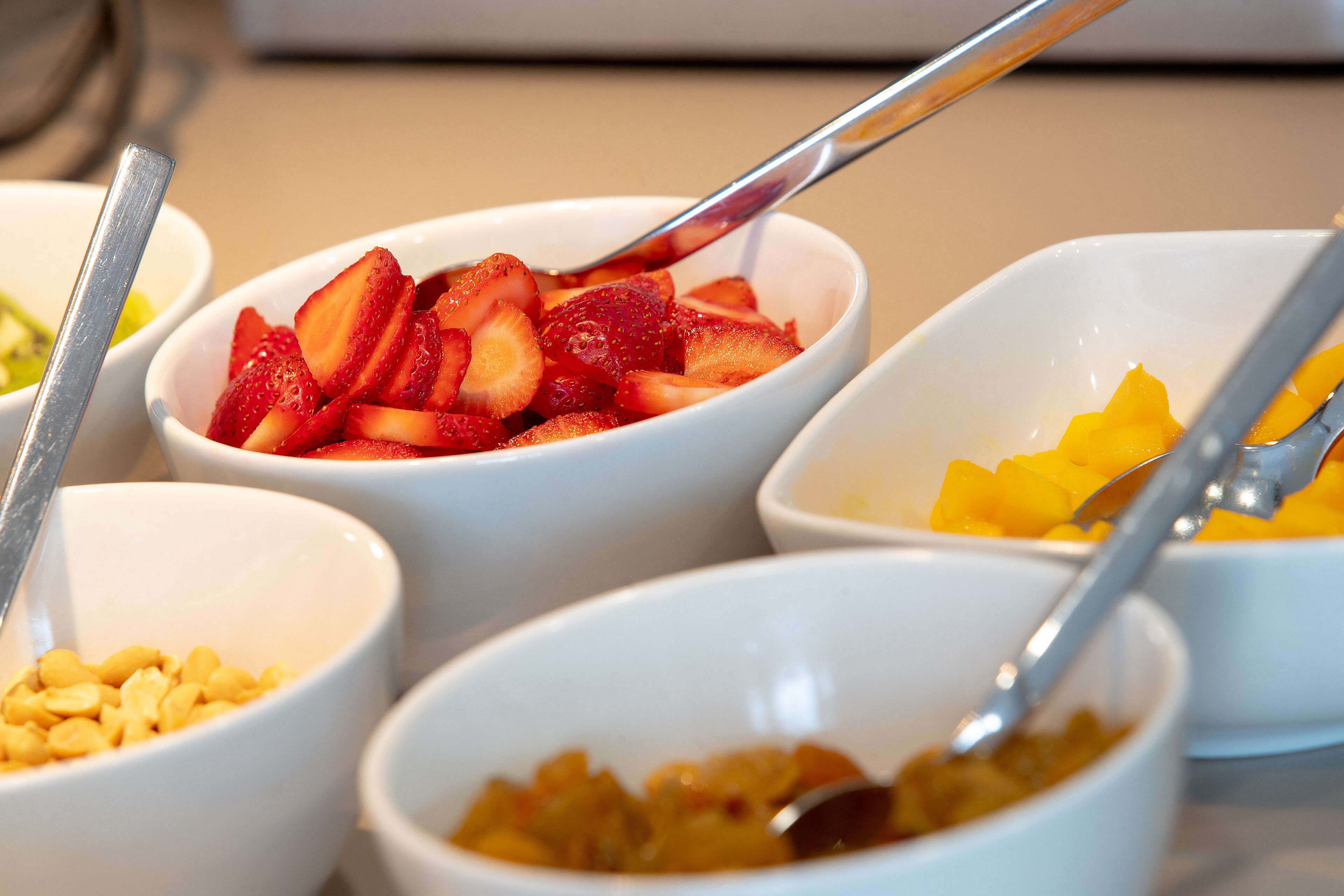 Diversos alimentos en tazones, como fresas y mangos.