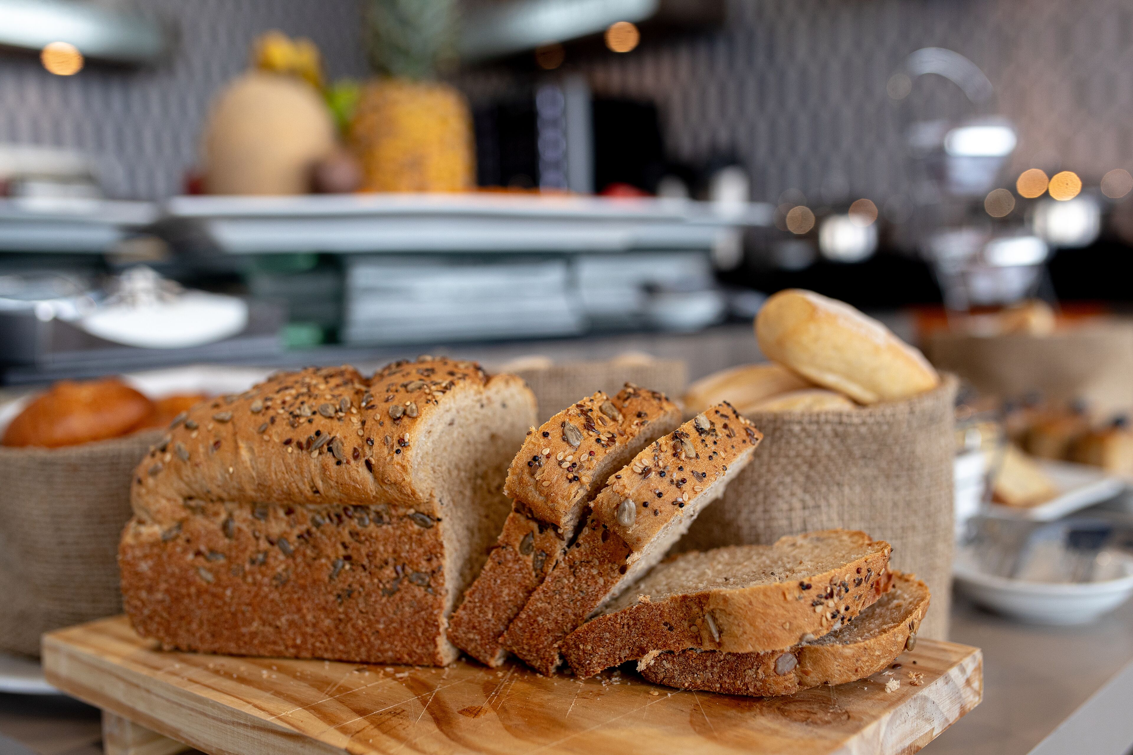 A loaf of seeded bread on a wooden board.