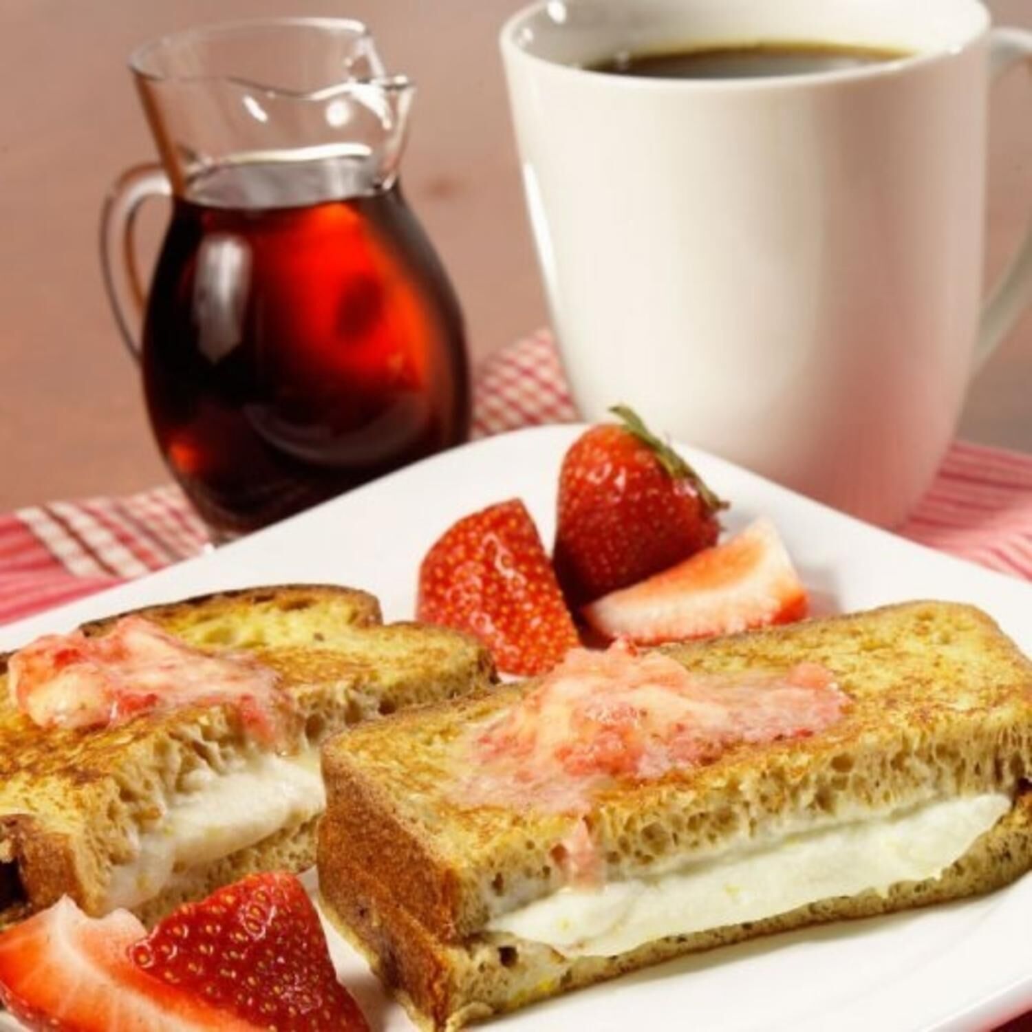 Fransk toast med jordbær og en kande sirup.