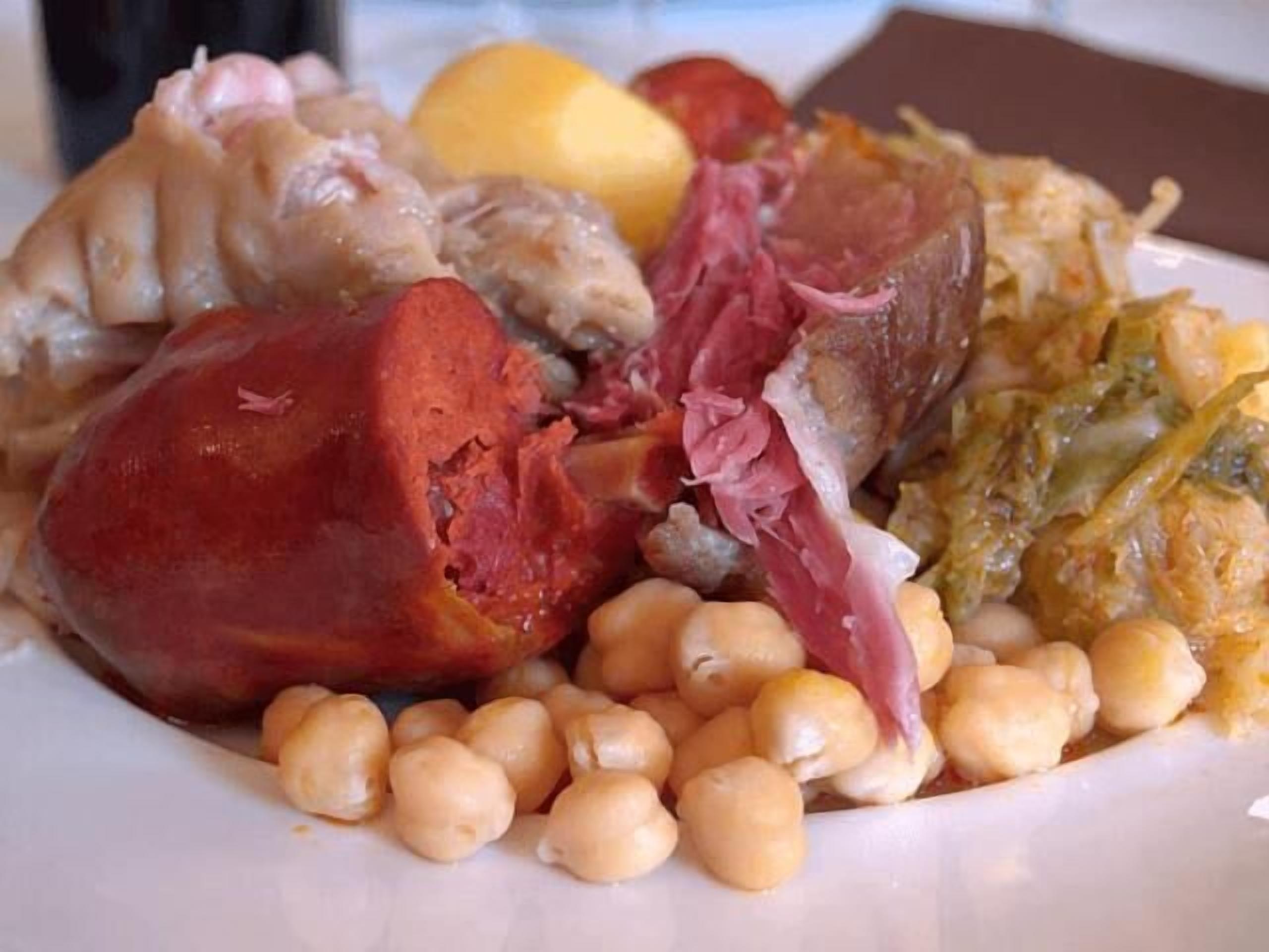 A plate of food including sausages, chickpeas, and vegetables.