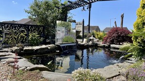 A garden with a pond, a pergola, and a sign for 'Apple Tree West House'. - Bojangles Guest House (Gretna)