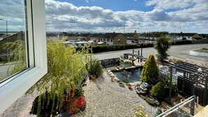 A residential area with houses, a road, and a small pond with plants. - Bojangles Guest House (Gretna)