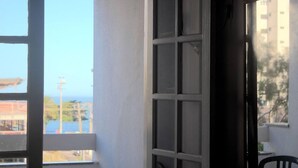 Una habitación con un ventanal grande, una puerta y vistas a un edificio y árboles.