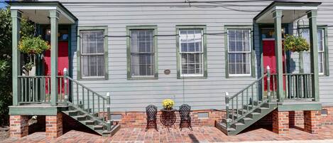 A two-story building with a brick base and green railings.