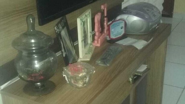 A wooden console table with a television, a glass bowl, a pink object, and a small cabinet. - Vila Mirante (Campina Grande)