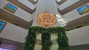 A high-ceiling atrium with a skylight, a chandelier, and framed artwork. - Paracatu Plaza Hotel (Paracatu)