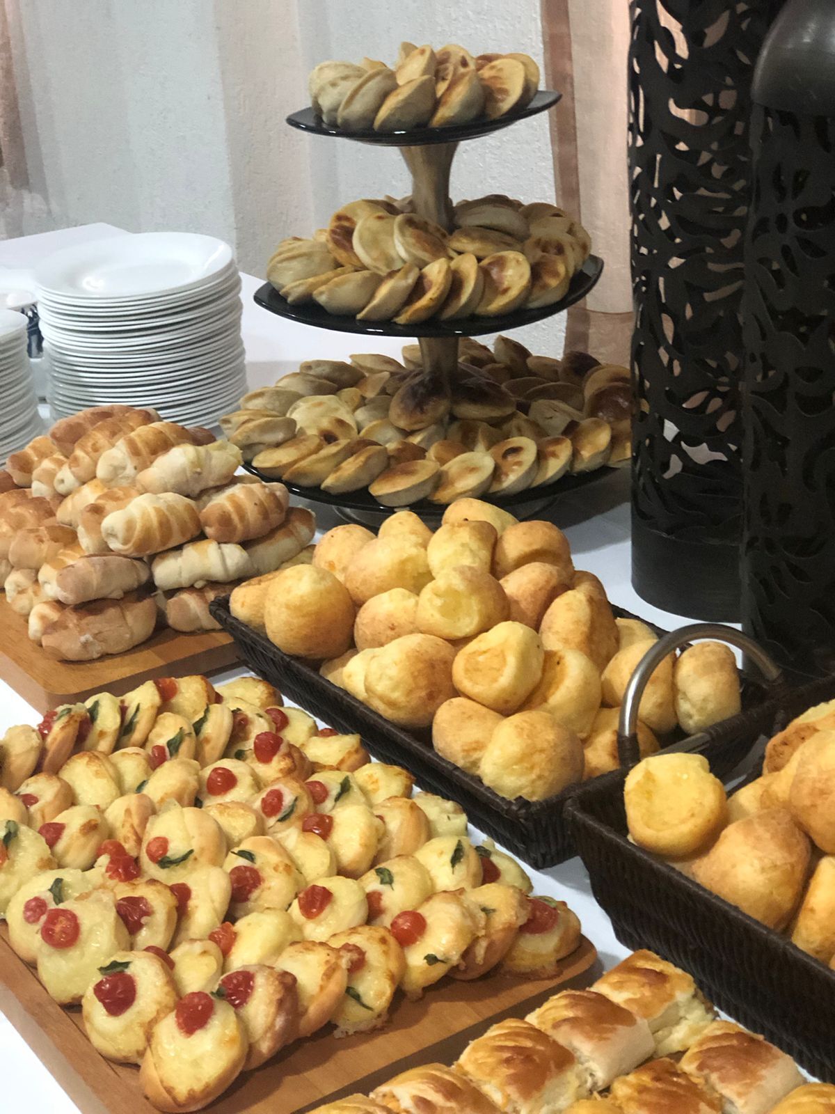 A buffet with various baked goods including croissants, bread rolls, and cheese-topped pastries.