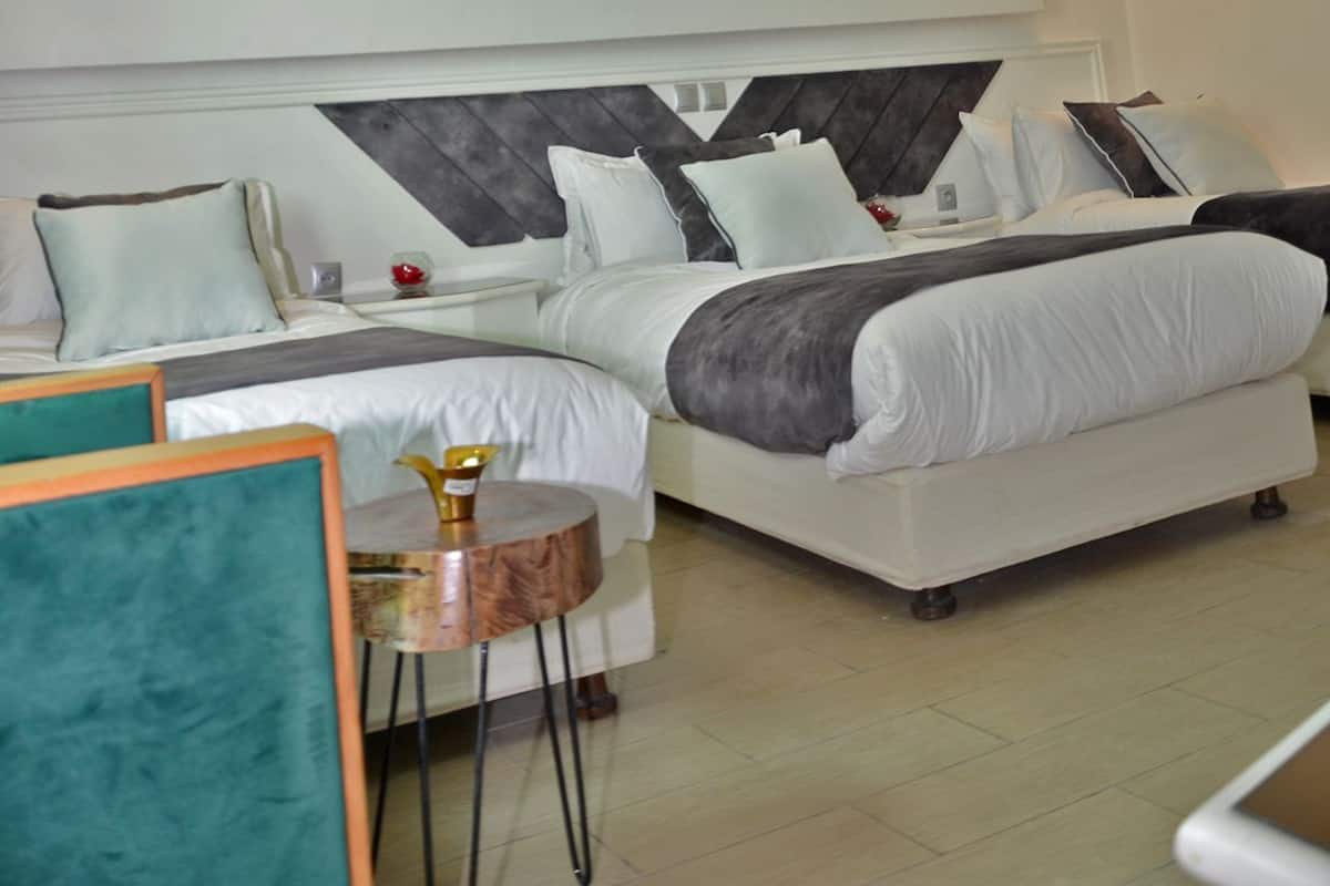 Un dormitorio moderno con una cama grande, una mesita de noche y una silla.