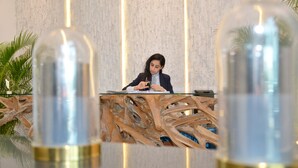 A reception desk with a modern design, featuring a glass top and a wooden base.