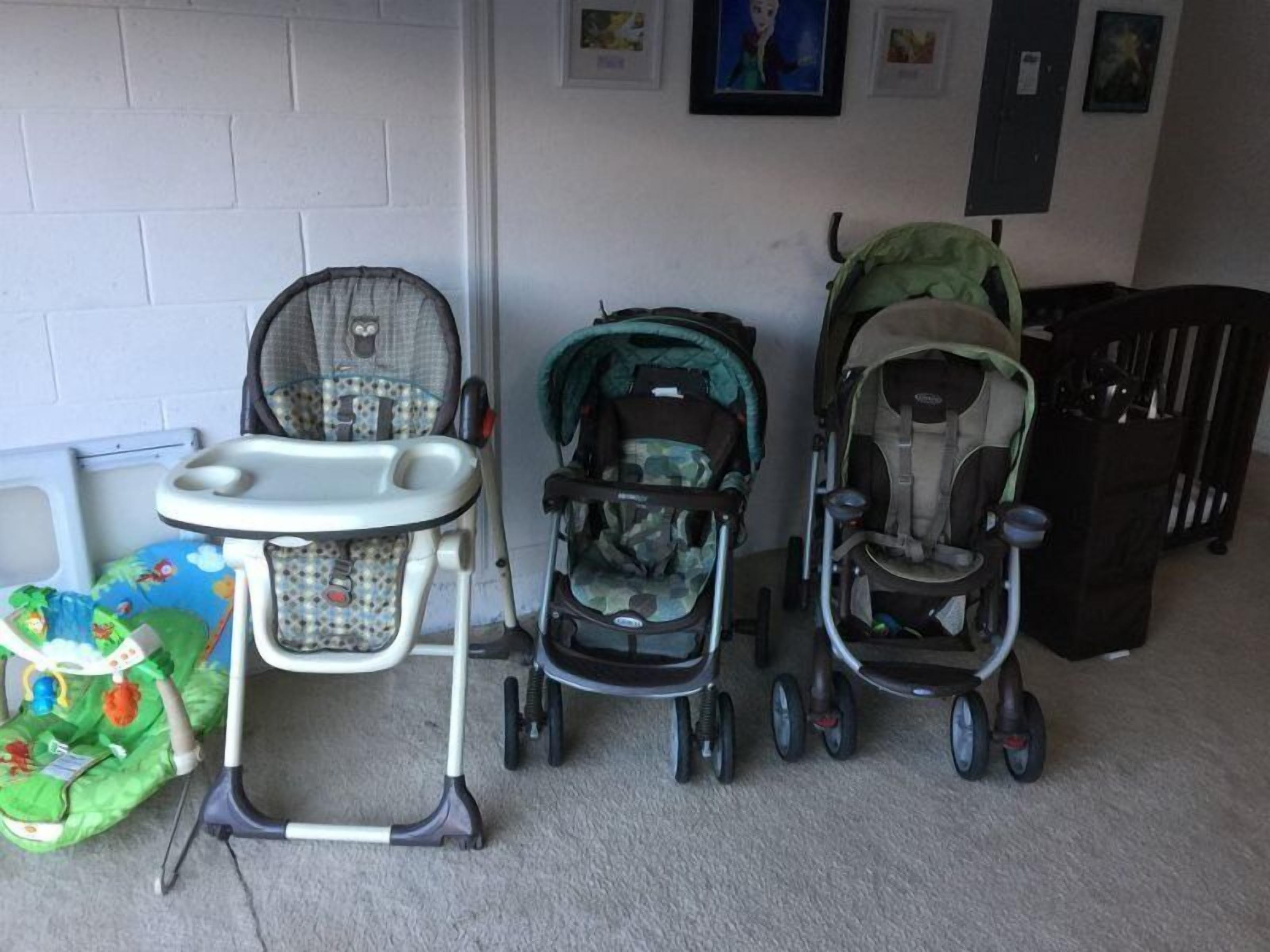 A room with a white brick wall, a baby walker, and two strollers.