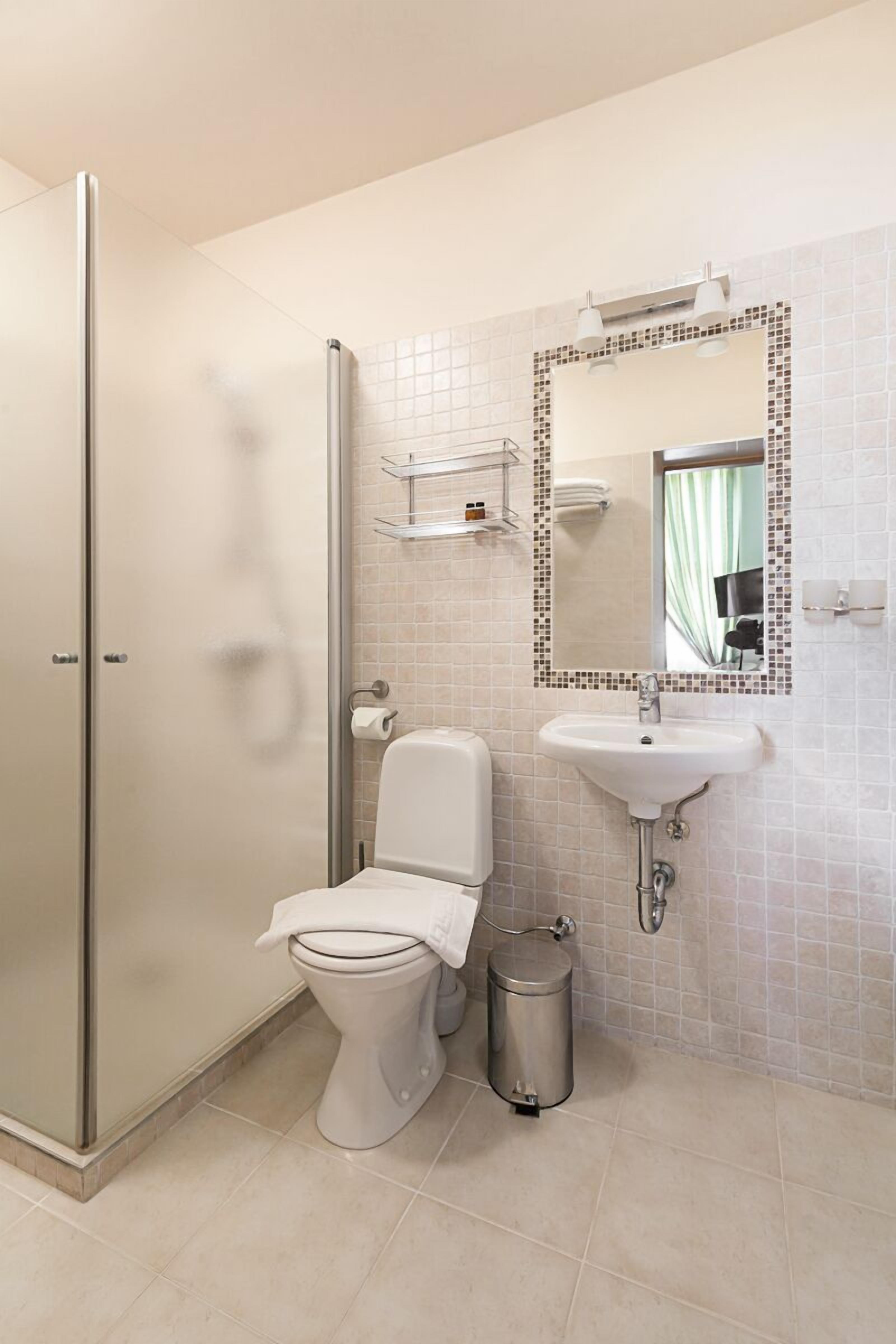 Un baño con inodoro, lavamanos y ducha.