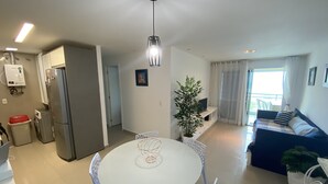 A modern apartment with a dining area, kitchen, and living room.