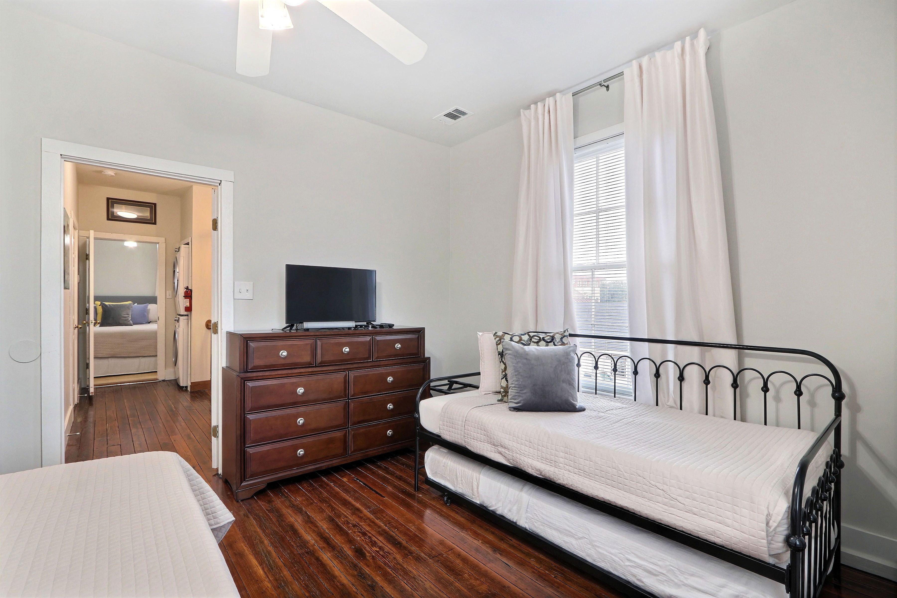 A bedroom with a bed, dresser, and television.