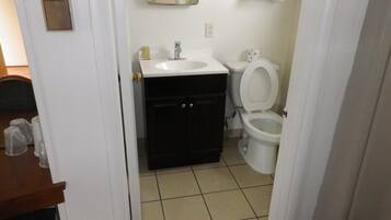 A bathroom with a sink, toilet, and mirror.