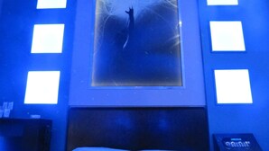 A room with a bed, a wall-mounted poster, and a digital clock. - Uman Hotel (Motel) (Buenos Aires)