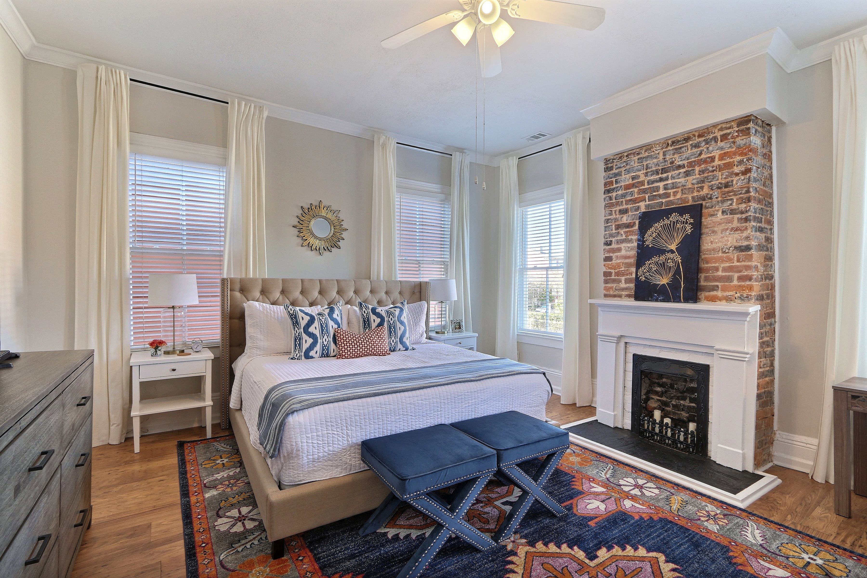 A bedroom with a large bed, a fireplace, and a view of the outdoors.