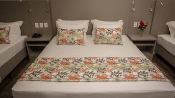 A hotel room with a large bed, two bedside tables, and a nightstand with a phone.