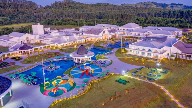 Un resort con un amplio área de piscina, un pabellón y jardines bien cuidados.