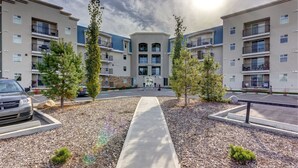 Un complesso residenziale moderno con cortile interno, area parcheggio e cielo sereno.