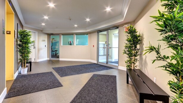 Un'ampia hall con parete curva, reception e zona relax.