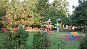A playground with a slide, climbing structures, and a swing set.