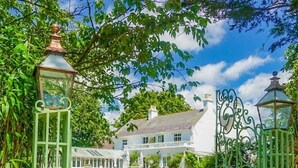 A pathway leading to a white house with a green gate and lanterns. - Cedar House Boutique B&B (Christchurch)