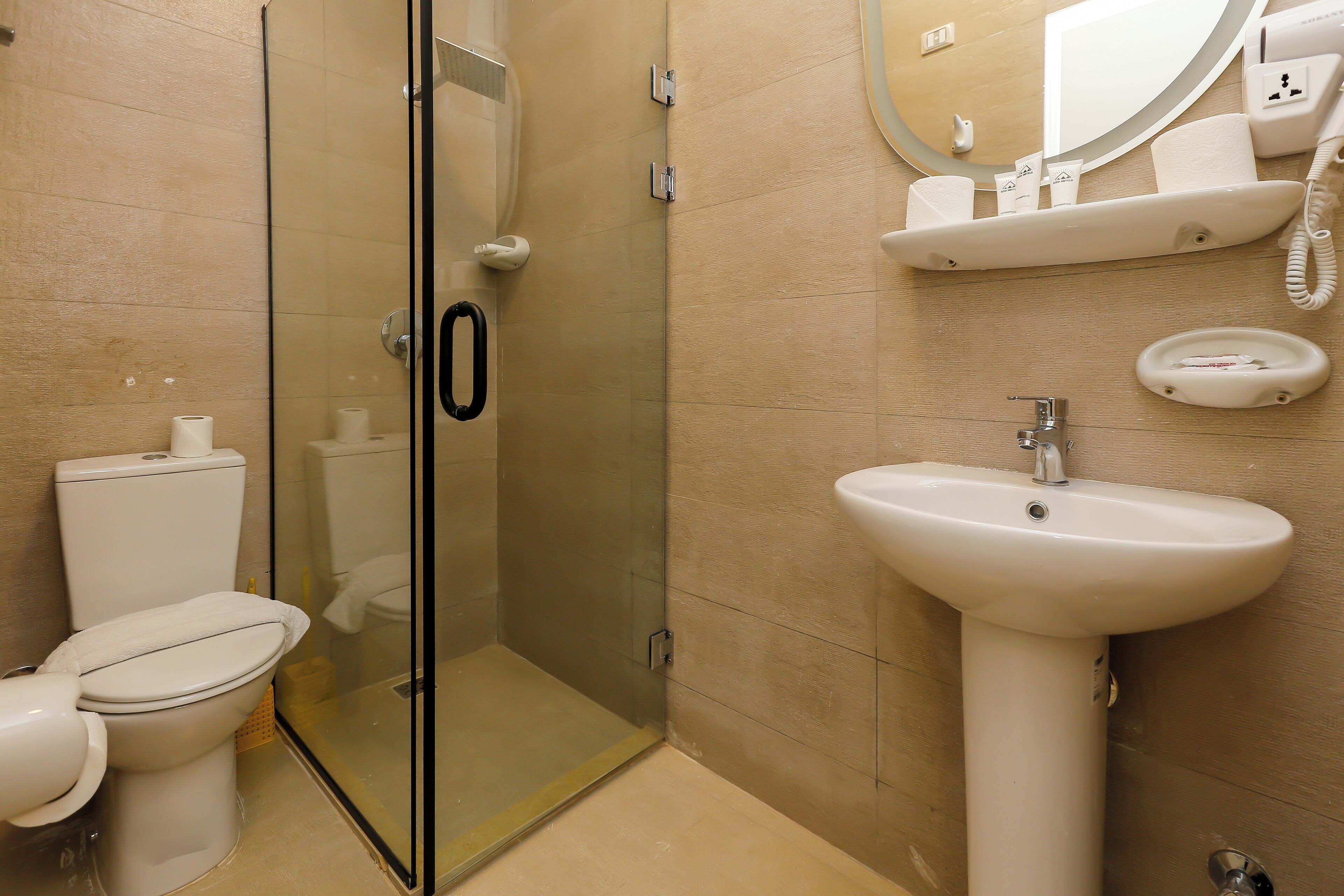 Ein modernes Badezimmer mit einer Dusche in Glasabtrennung, einer Toilette und einem Waschbecken.