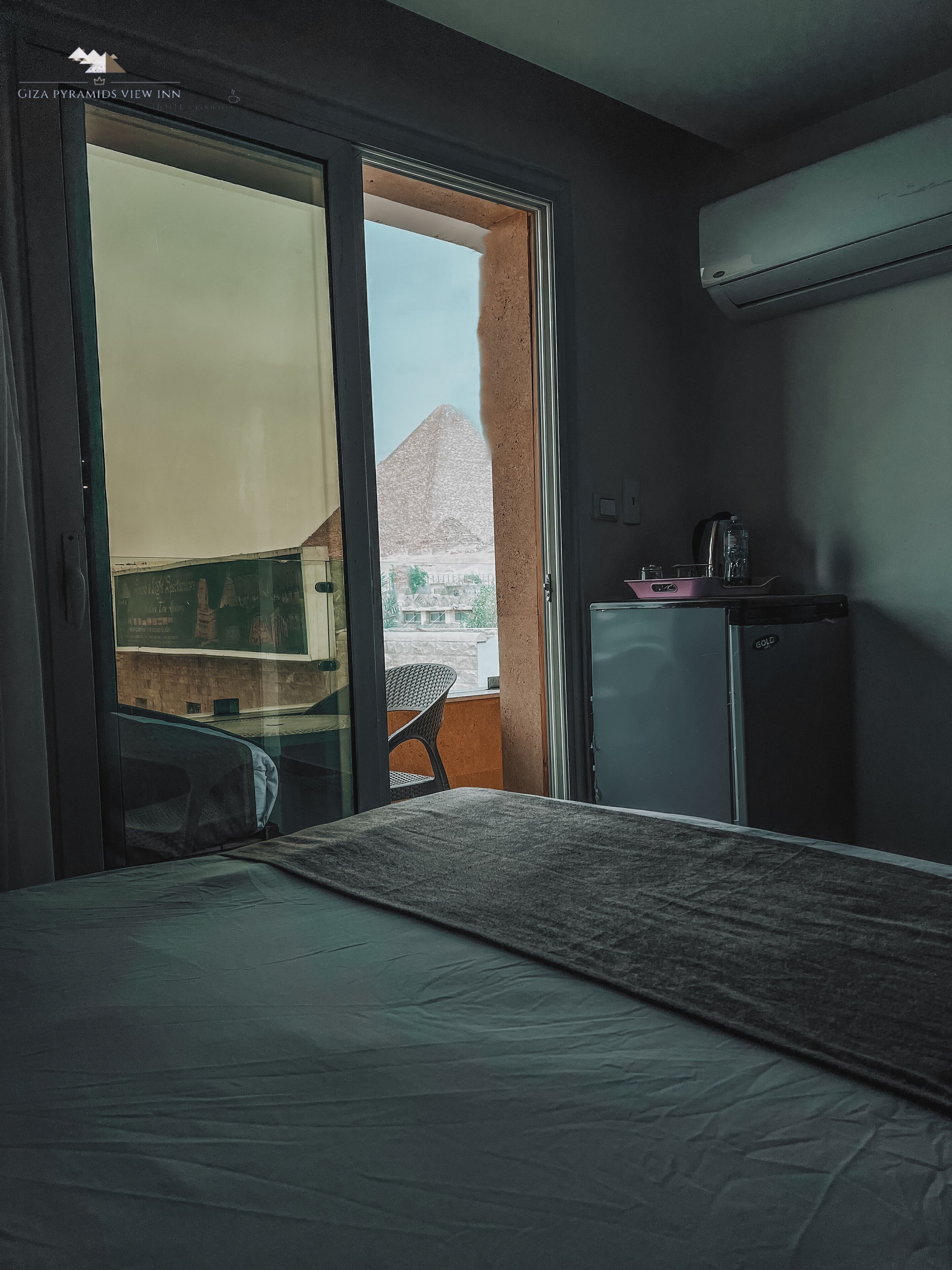 Une chambre d’hôtel avec un lit, une petite kitchenette et une vue sur la montagne.
