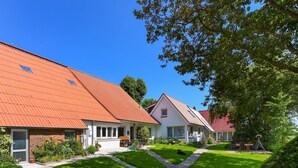Une rangée de maisons aux toits rouges et à la pelouse bien entretenue.