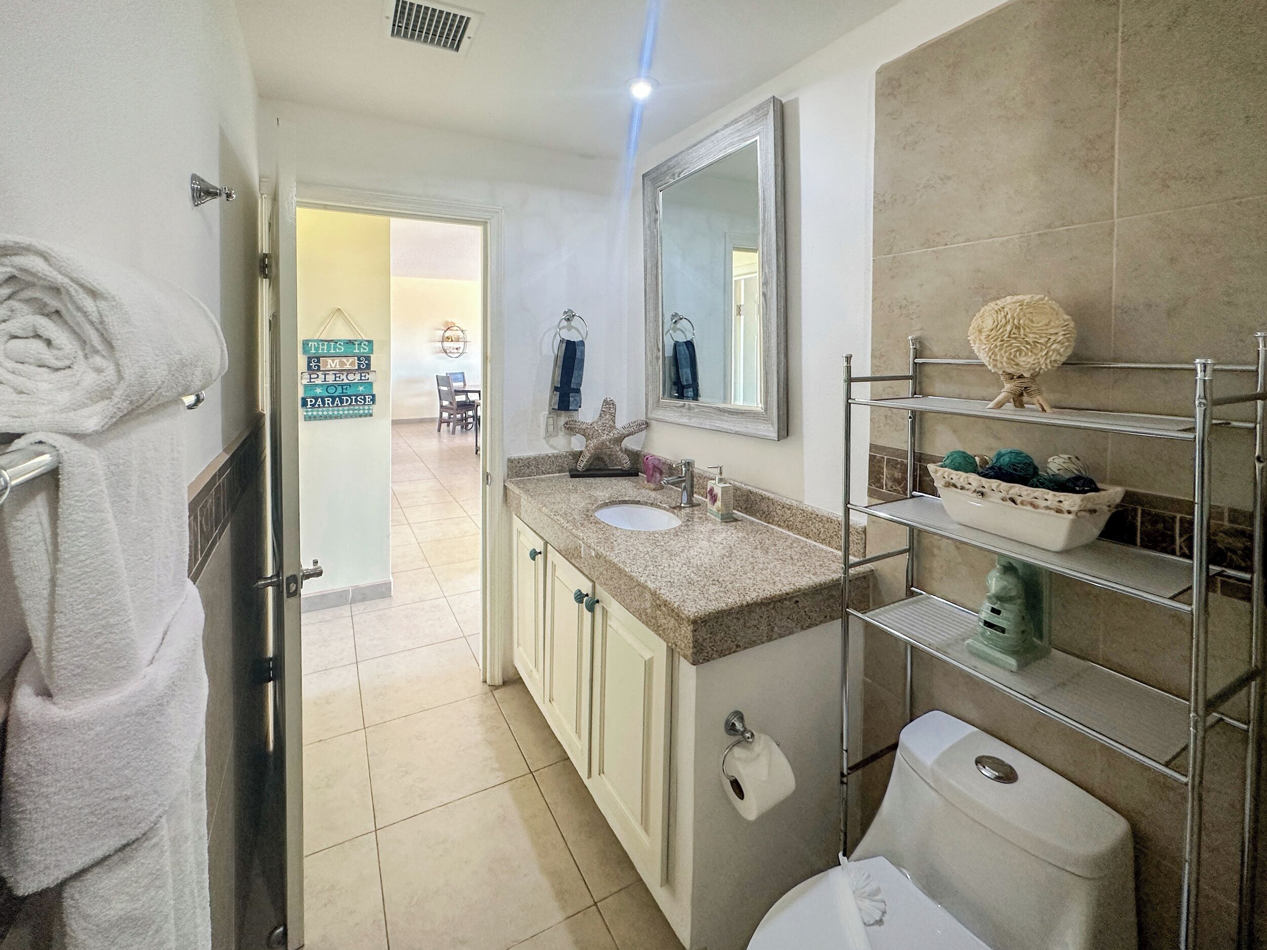 A bathroom with a sink, toilet, and a towel rack.