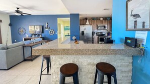 A modern kitchen with granite countertops, stainless steel appliances, and a blue accent wall.