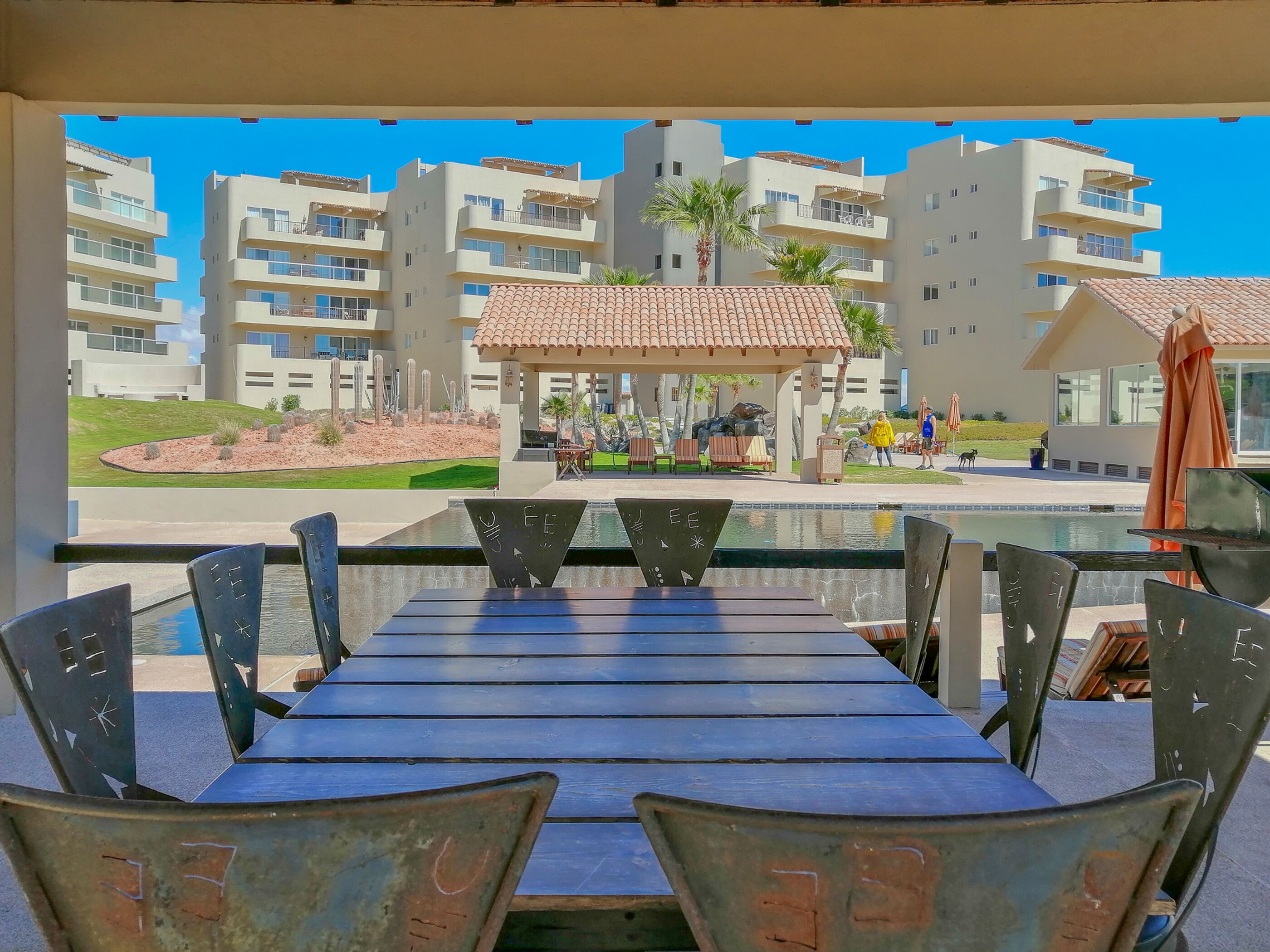 Comedor con vista a una piscina y edificios.