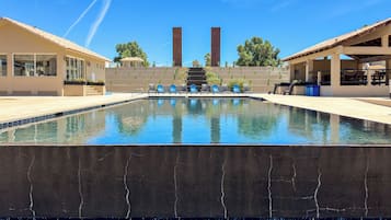 Relax by the pool surrounded by a low wall and comfortable seating.