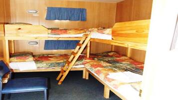 Una habitación pequeña con literas, un escritorio y una silla.
