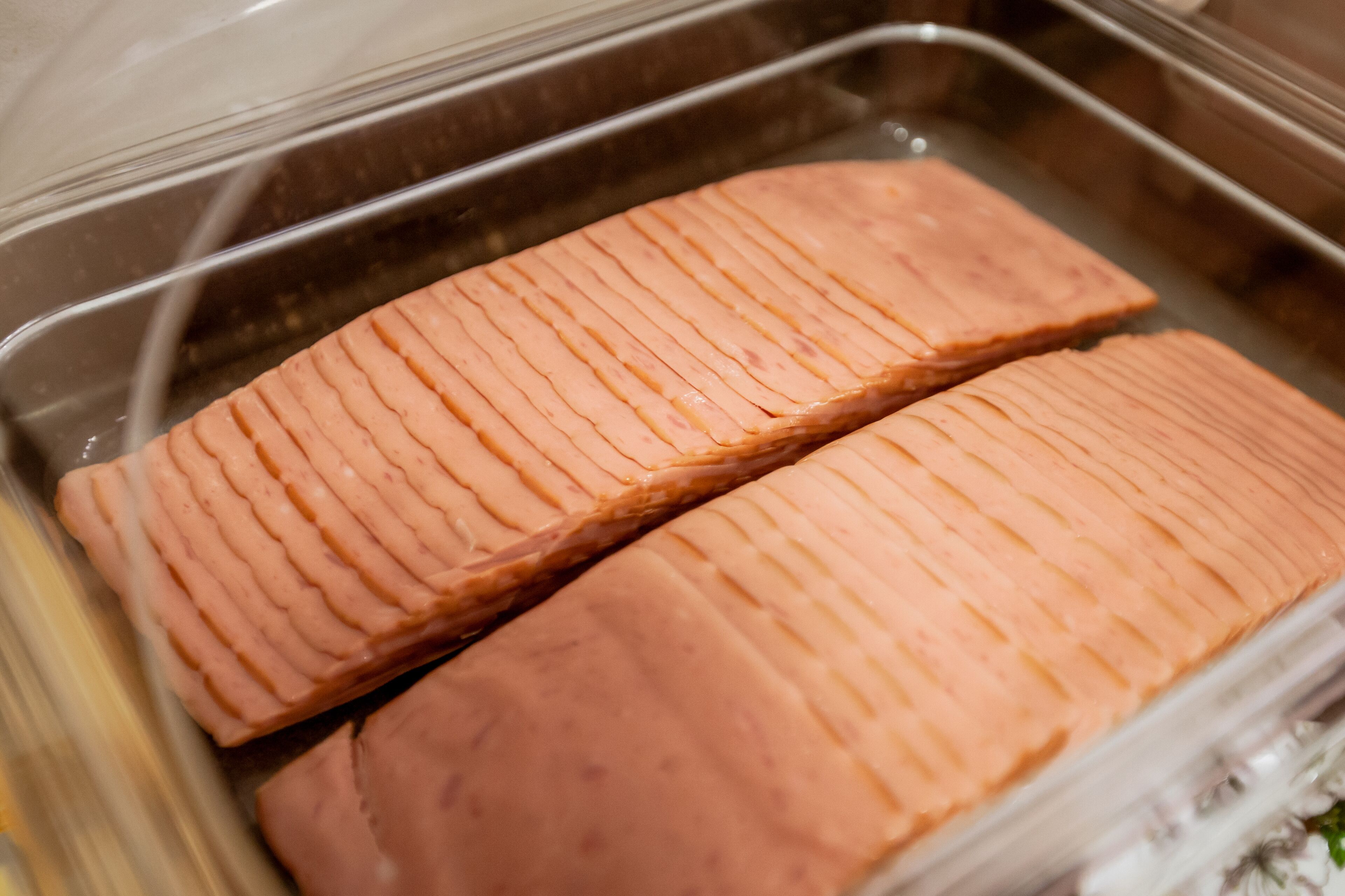 Two salmon fillets in a stainless steel container.