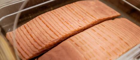 Two salmon fillets in a stainless steel container.