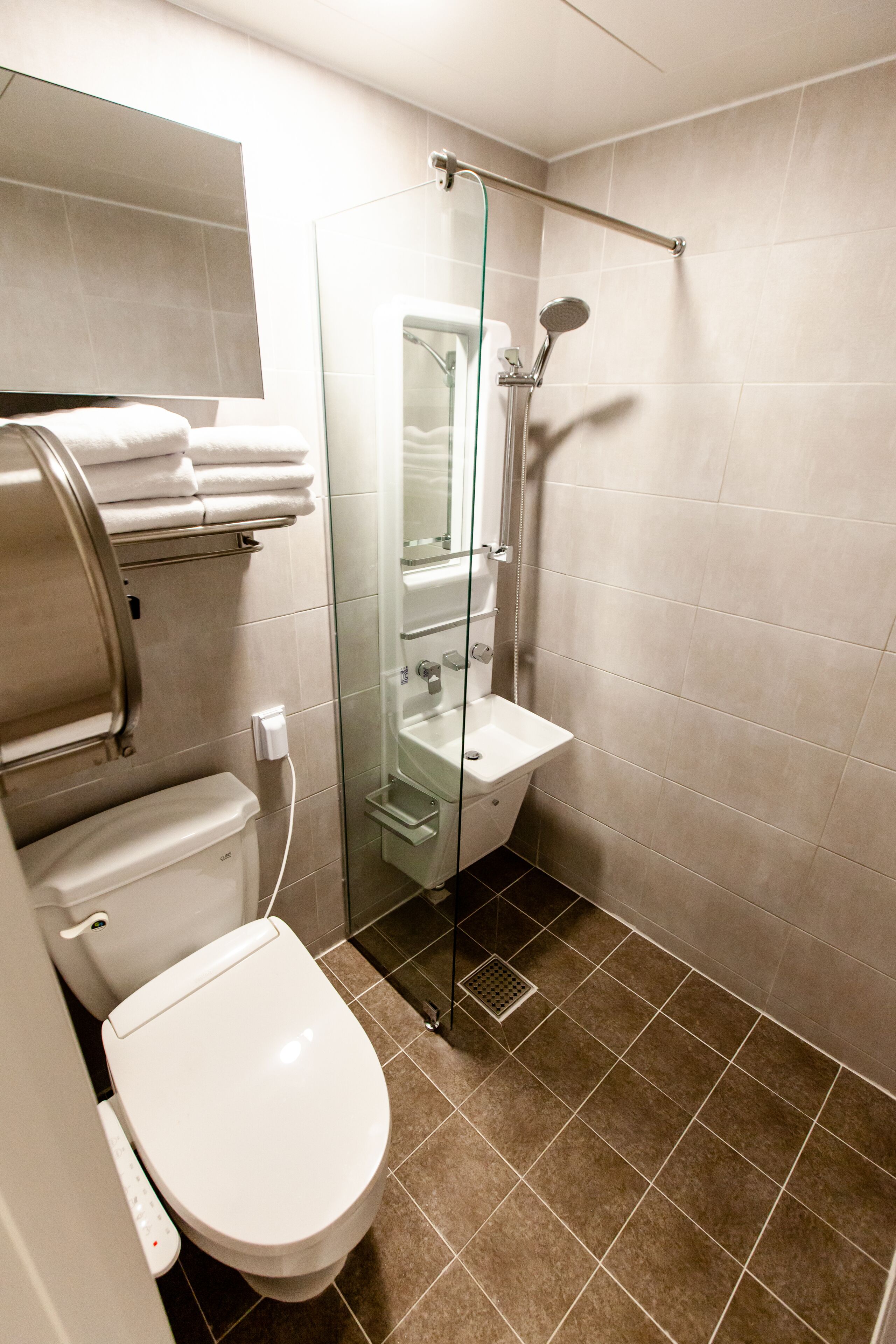 Une salle de bain moderne avec des toilettes, une douche à parois de verre et un lavabo.