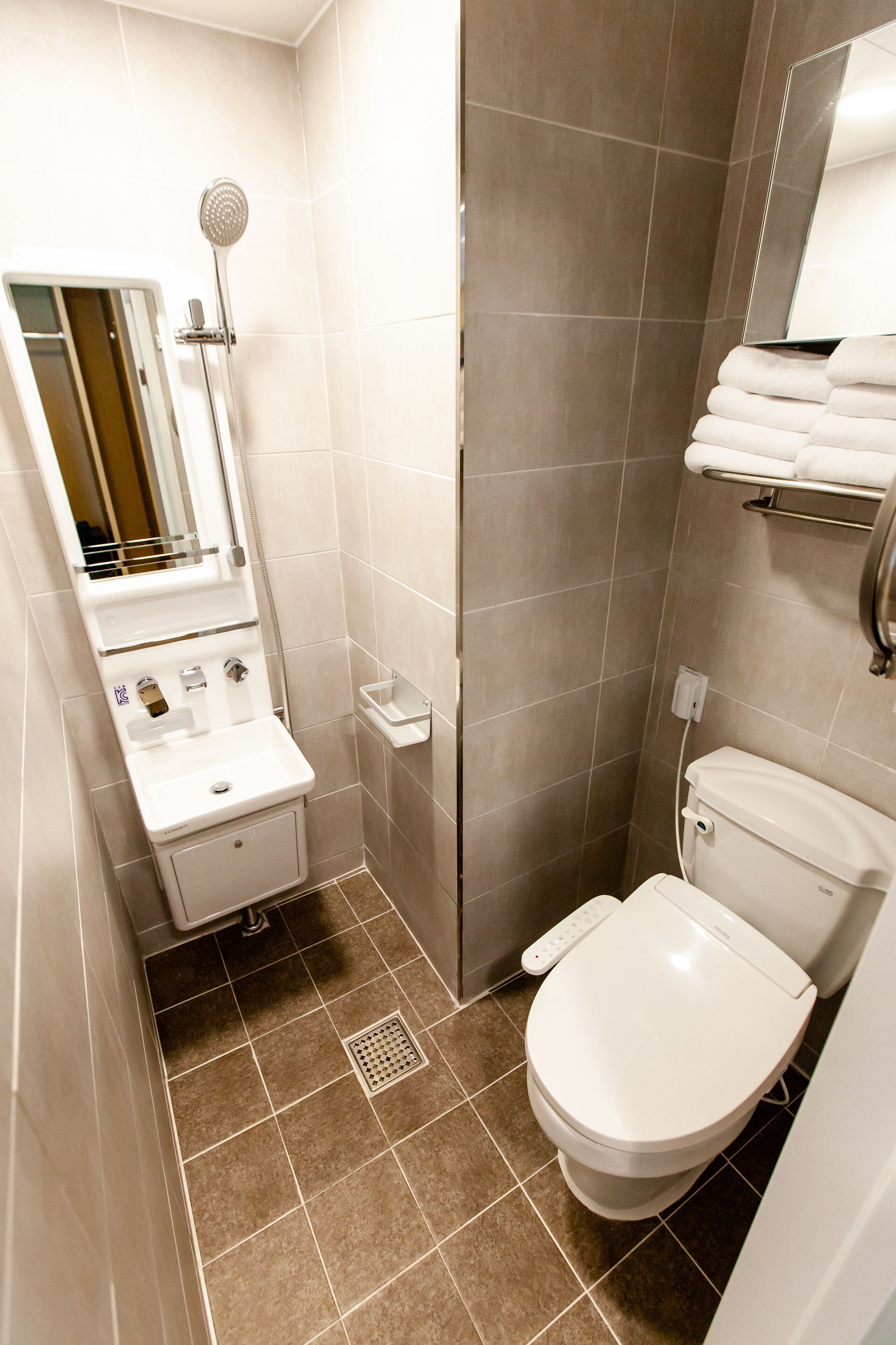 A modern bathroom with a toilet, sink, and shower.