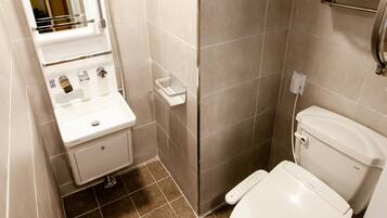 A modern bathroom with a toilet, sink, and shower.
