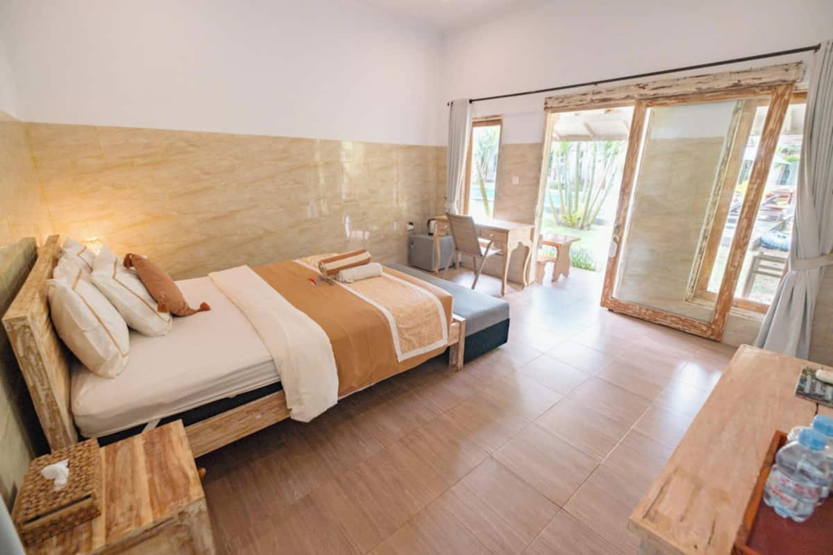 Ein Schlafzimmer mit einem Bett, einem Nachttisch und Blick ins Freie.