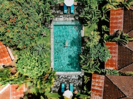 Una piscina al aire libre, tumbonas