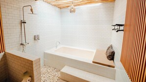 A modern bathroom with a white-tiled shower, a freestanding bathtub, and a wooden ceiling. - Agung Wiwin Homestay (Munggu)