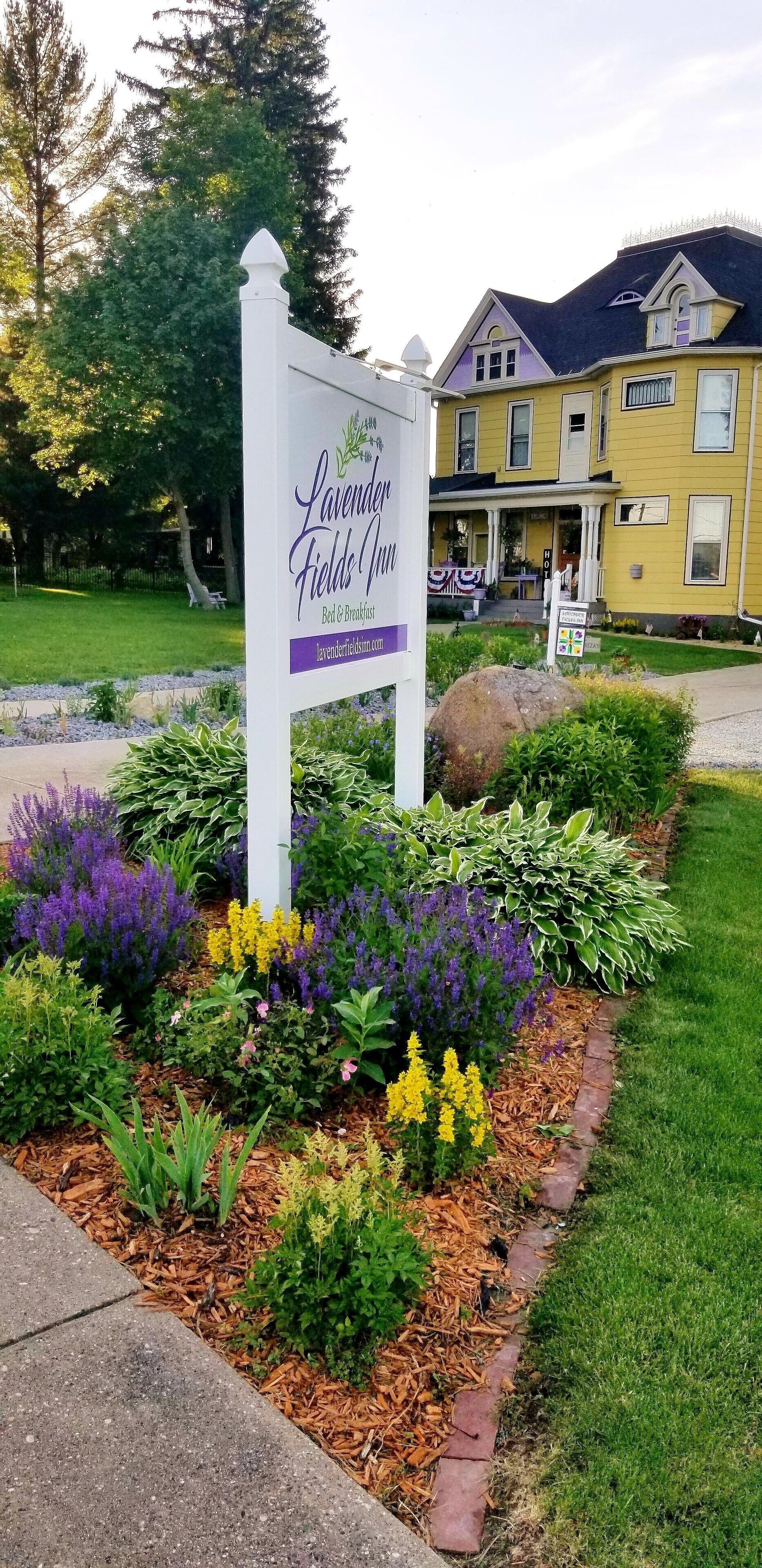 A sign for Lavender Fields Inn with a garden in front.
