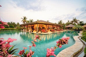 A resort with a large pool, lounge area, and tropical vegetation. - Authentic Khmer Village Resort (Siem Reap)