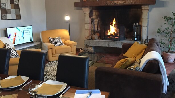 Una sala de estar acogedora con chimenea, asientos cómodos y televisión.